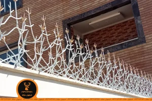 حفاظ شاخ گوزنی مدل گلخاری ارتفاع ۸۰ تراکم ۳۶ رنگ سفید و گلهای طلایی روی دیوار سنگی سفید پس زمینه نمای دیوار آجر تولید اصفهان حفاظ